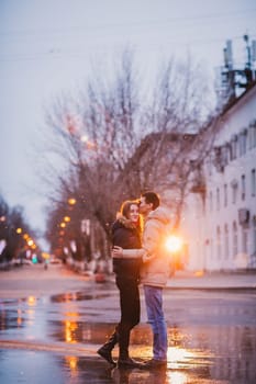 Portrait of young beautiful couple kissing in an autumn rainy day. Love and couple relationships concept.