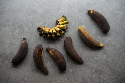 Rotten bananas on grey background.