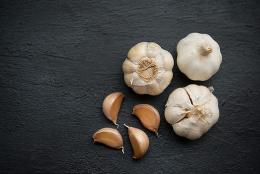 Top view garlic cloves and bulb with copy space on dark background.