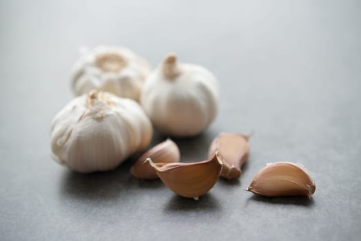 Garlic cloves and bulb with copy space on dark background.