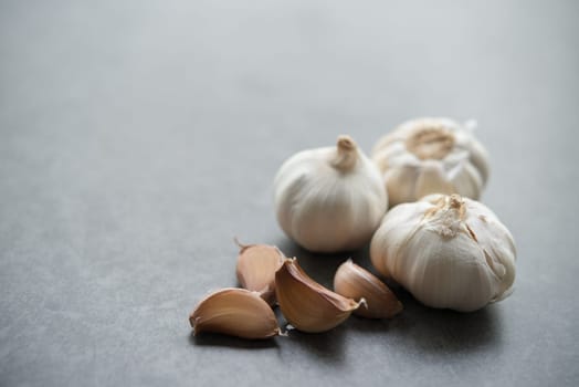Garlic cloves and bulb with copy space on dark background.