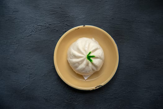 Flat lay Baozi or bao dim sum on plate with copy space on dark background.