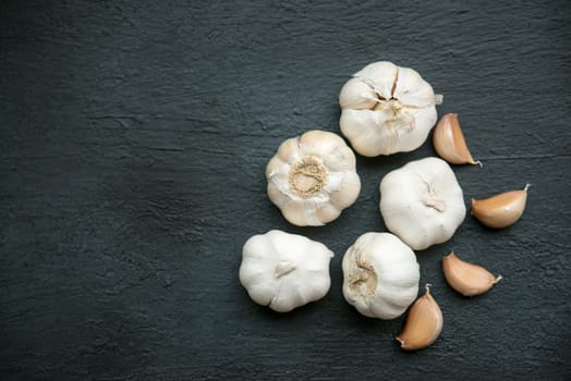 Top view garlic cloves and bulb with copy space on dark background.
