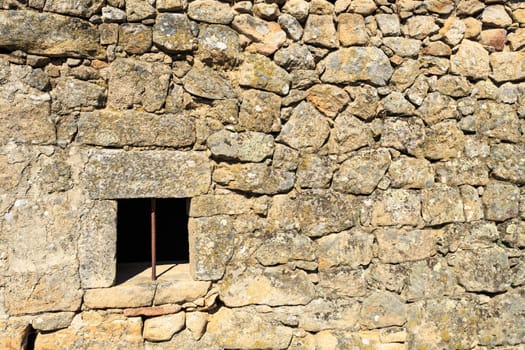 View of a wall showing the traditional granite stone masonry architecture and a ventilation slot of a house in the village of Mesquitela, Gouveia, Portugal