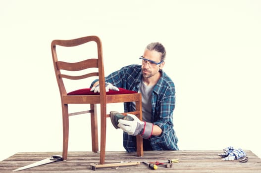 worker in blue plaid  shirt repair old chair