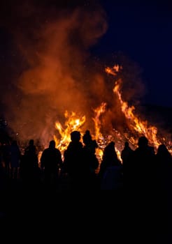 silhouettes of people in frontof big easter fire