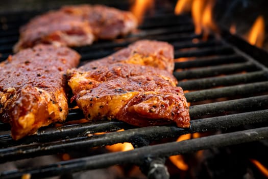 grilled pork with flames on charcoal barbecue