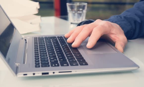 business mans hand on computer keyboard in office