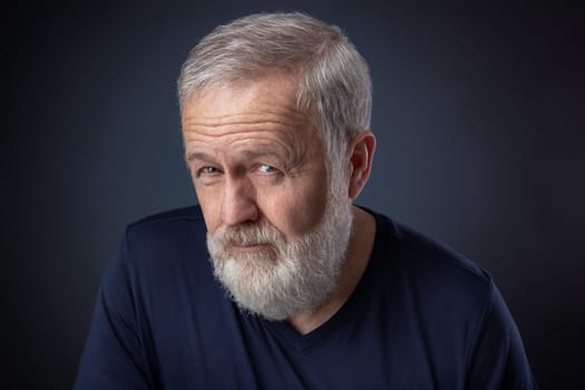 Portrait of senior with gray beard and a deep look