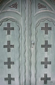 Old metal door with symbolic crosses, religion and construction