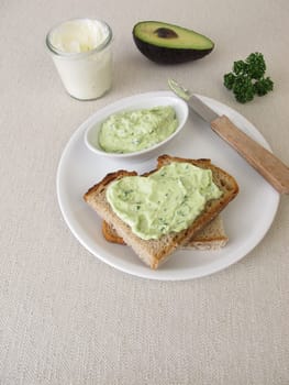 Guacamole with avocado, fresh cheese and parsley on slice of bread