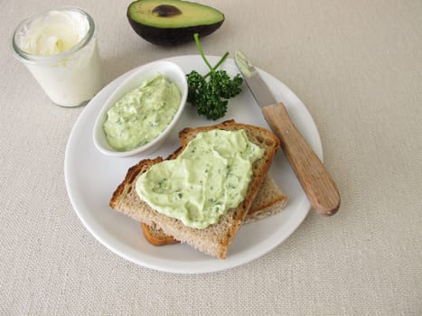 Guacamole with avocado, fresh cheese and parsley on slice of bread