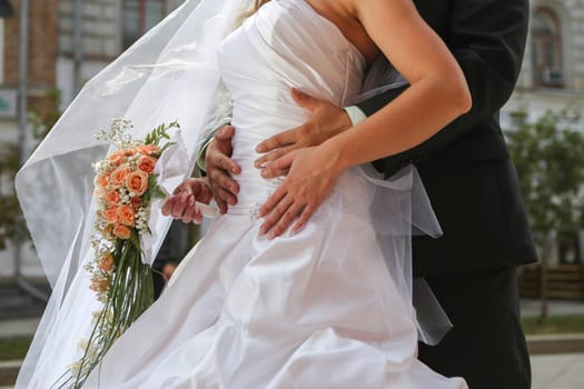 Bride with groom holding wedding bouquet at ceremony