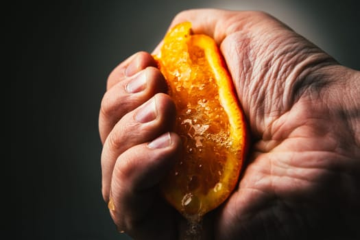 man dramatic squeezes orange. Concept squeezed a man is tired from work.