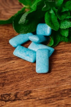 chewing gum and green mint on a wooden background