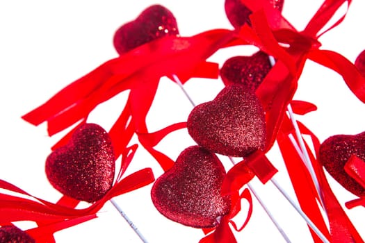 Red valentine heart shaped decorations with ribbon and bows isolated over white background.