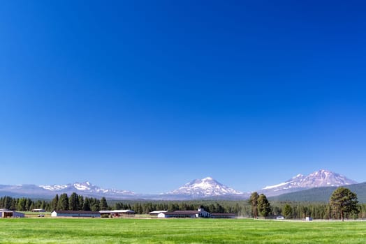 Ranch in Central Oregon with Three Sisters mountains in the background near Bend