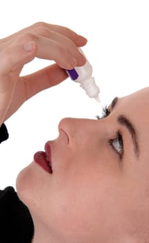 A close up image of a young woman putting eye drops is her dry eye.white open eyes, looking up, isolated for white background.