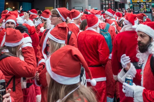 London, UK - December 2018 : Group of people dressed in santa outfits and taking part in a themed SantaCon event