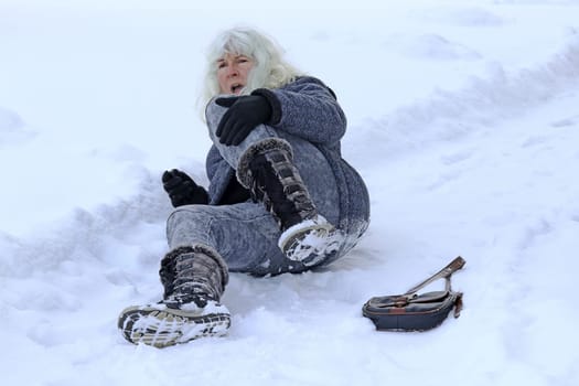 A woman slipped, fell and injured herself on the wintry road. Fall on a snow-covered road