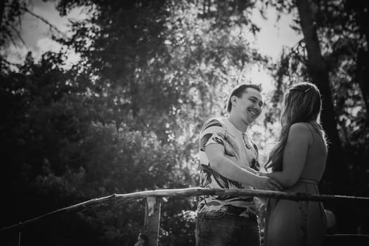 Black white photography romantic young couple kissing and stand to bridge on background