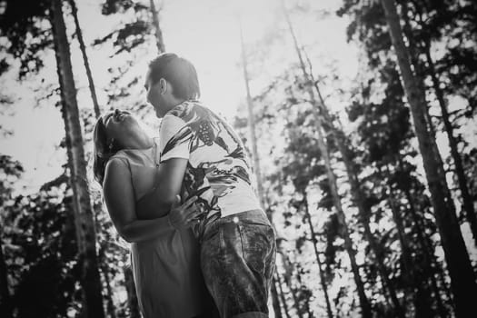 Black white photography romantic young couple kissing on background summer forest