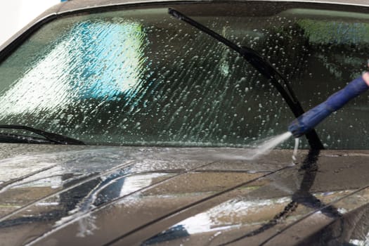 Manual car wash with pressurized water in the car wash outside.