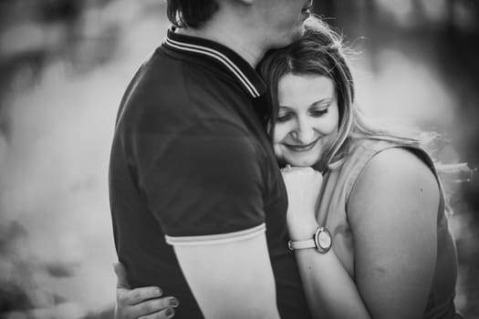 Black white photography romantic young couple kissing on background summer forest