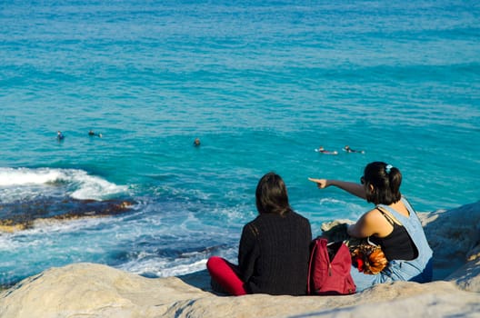 Portrait from behind of young woman sitting and looking on Sea . Concept for travel or freedom.