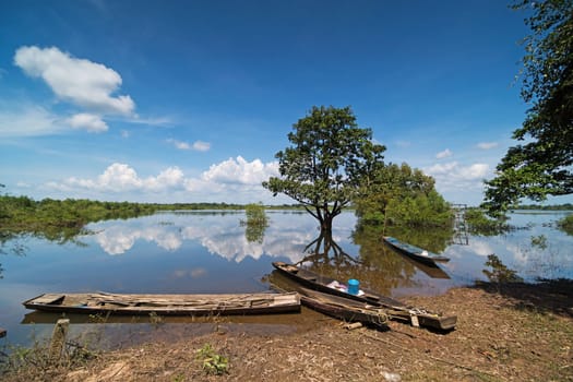 Flooded Landscape With Fishing Boats, standing water with reflection of clouds