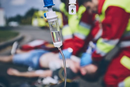 Cardiopulmonary resuscitation. Rescue team (doctor and a paramedic) resuscitating the man on the road.