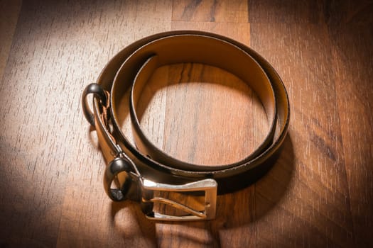 Leather Belt Men Dress Rolled Up on Wooden Floor Vignette Spotlight Floor