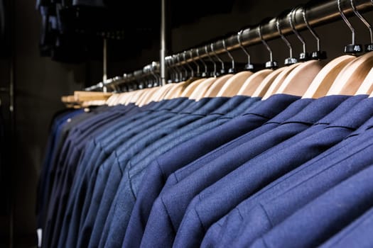 Blazer Jacket on Rack in Store Men Fashion Wooden Hangers Clothes Suit Professional Luxury Many Multiple Closeup