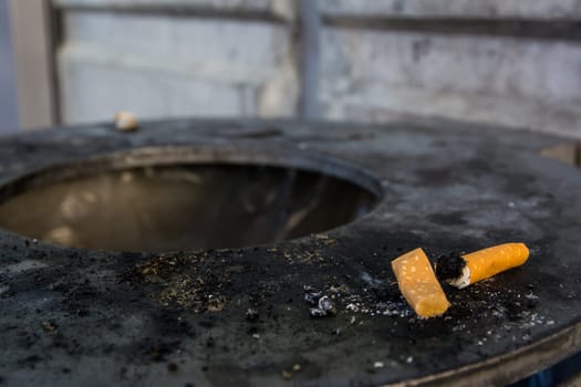 Cigarette Butt Filter Ashes on Trash Can Rim