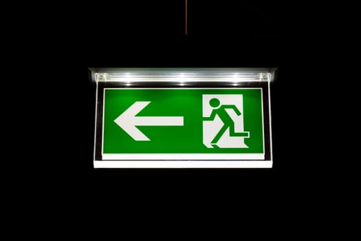Modern Exit Sign Glass White Illuminated on Black Background Interior