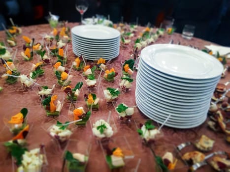 Buffet dinner on a table spread with finger food and stacked ceramic dishes