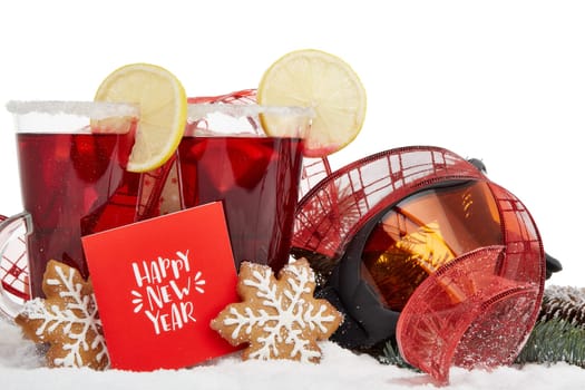 Winter holidays still life with fir tree branch, ski glasses, fruit tea, gingerbread cookies and Christmas decorations on snow on a white background. Happpy New Year. Greeting card. Winter vacation.