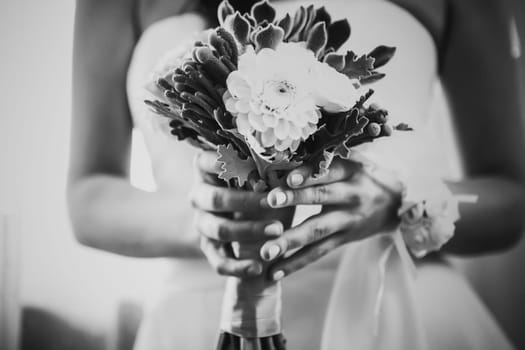 Black white photography beautiful wedding bouquet of flowers in hands the bride