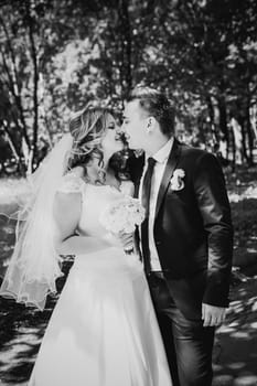 Black white photography happy couple bride and groom embracing they stand in a forest