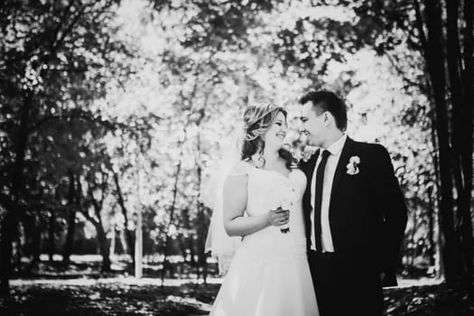 Black white photography happy couple bride and groom embracing they stand in a forest