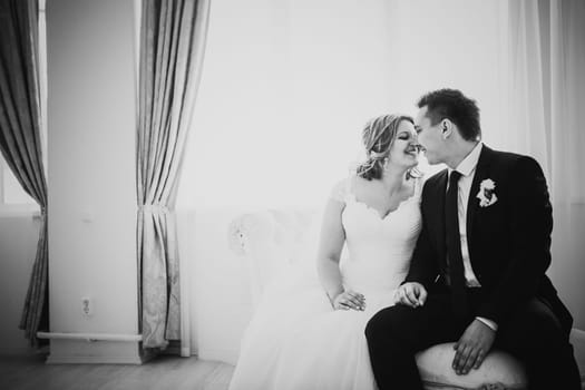 Black white photography bride and groom posing in a hotel room