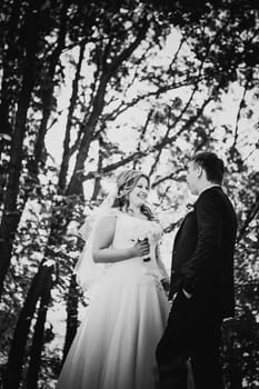 Black white photography happy couple bride and groom embracing they stand in a forest