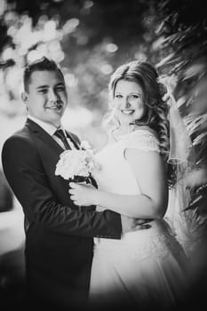 Black white photography happy couple bride and groom embracing they stand on background nature close-up