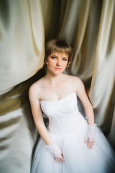 portrait of a beautiful young bride on the background of beautiful fabrics