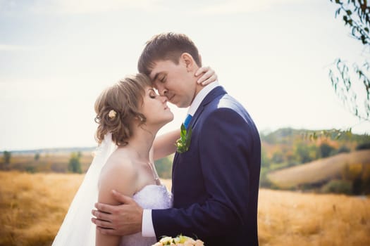 young bride and groom on the background of the field