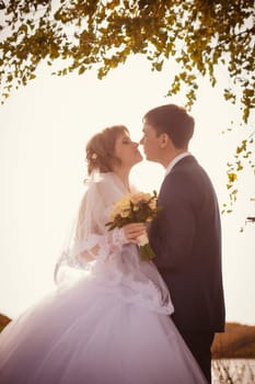 young bride and groom on the background of the lake