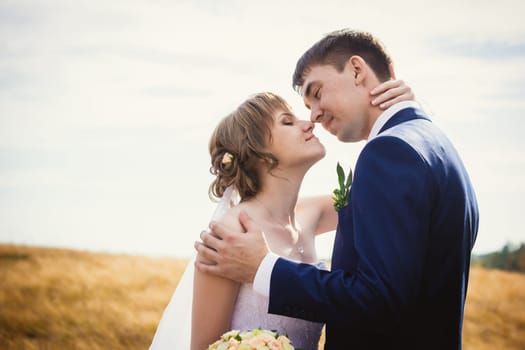 young bride and groom on the background of the field