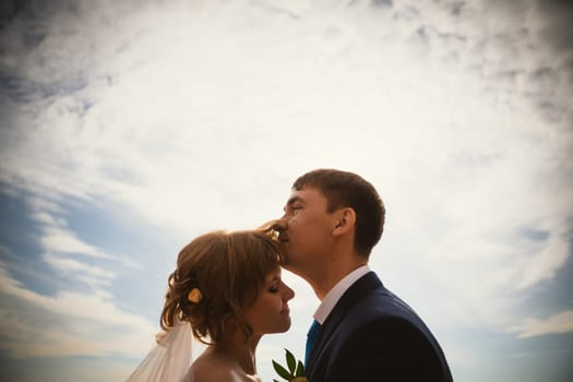 young bride and groom on the background sky