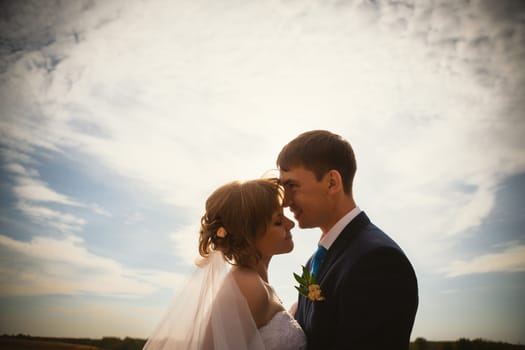 young bride and groom on the background sky