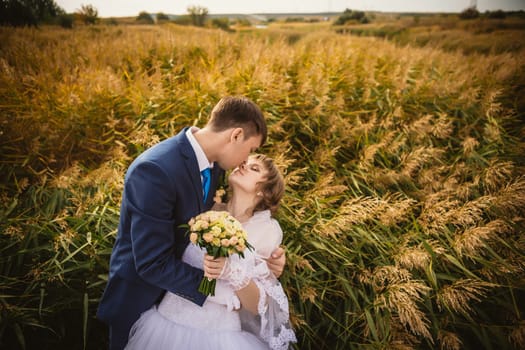 young bride and groom on the background of the field